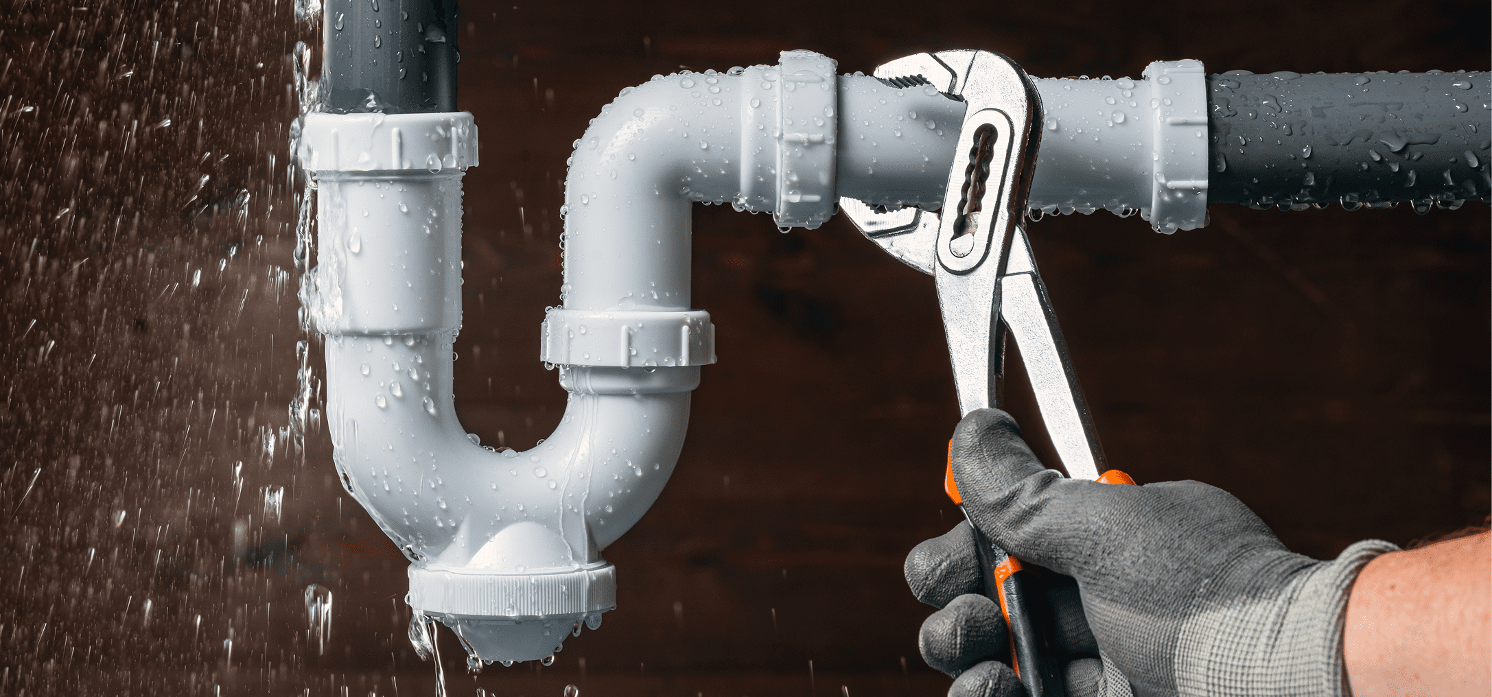 Hands tightening pipe using wrench