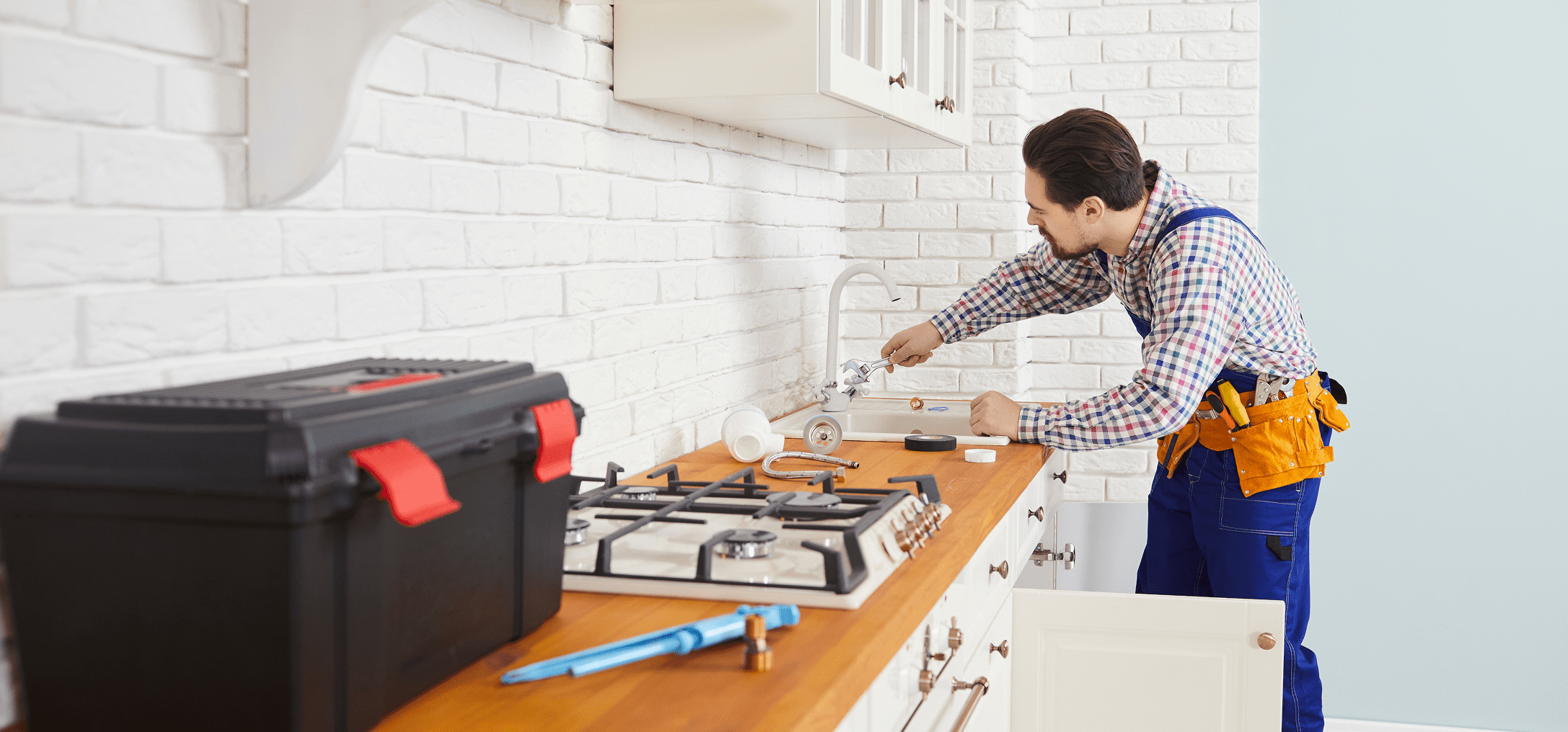 Technician working under kitchen sink